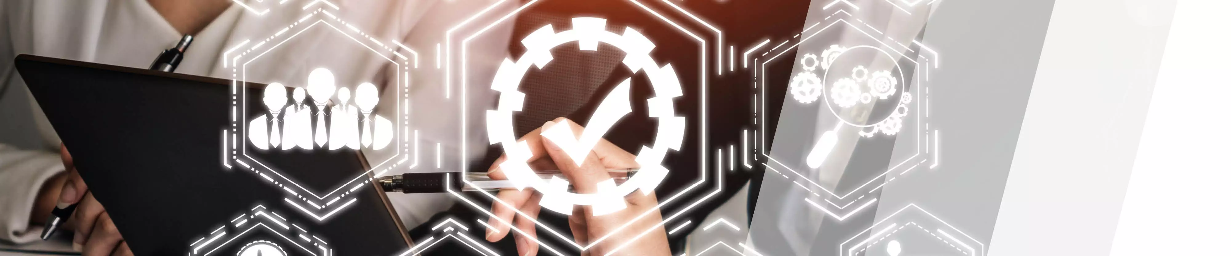 Grafik eines Zahnrads mit Häkchen, im Hintergrund Person am Laptop