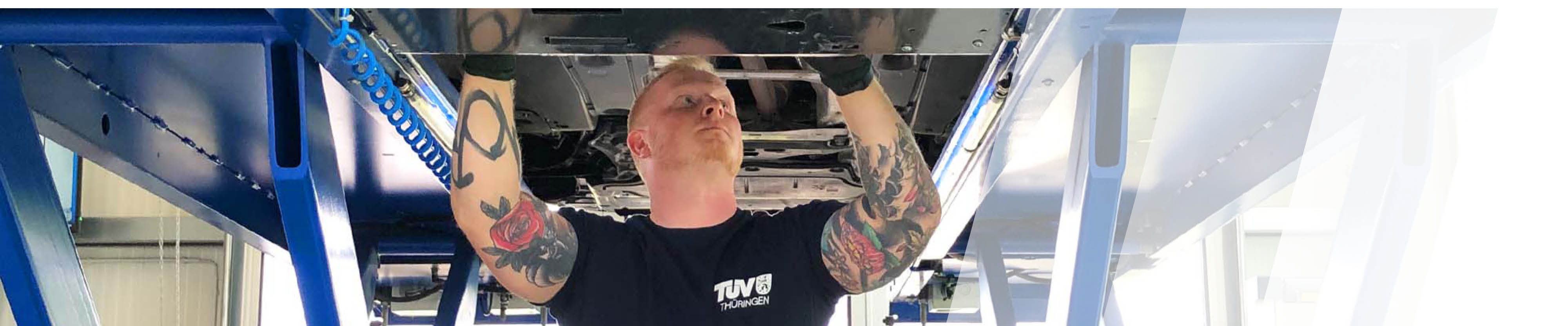 Ein Prüfer schaut unter die Karosserie eines Autos