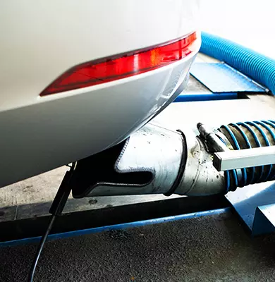 Ein Sammler nimmt die Abgase eines Fahrzeugs bei der Abgasuntersuchung auf