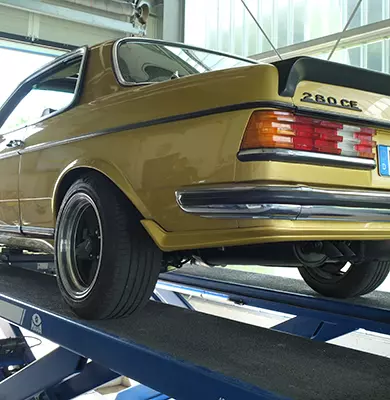 Ein Oldtimer auf einer Hebebühne in einer Auto-Werkstatt