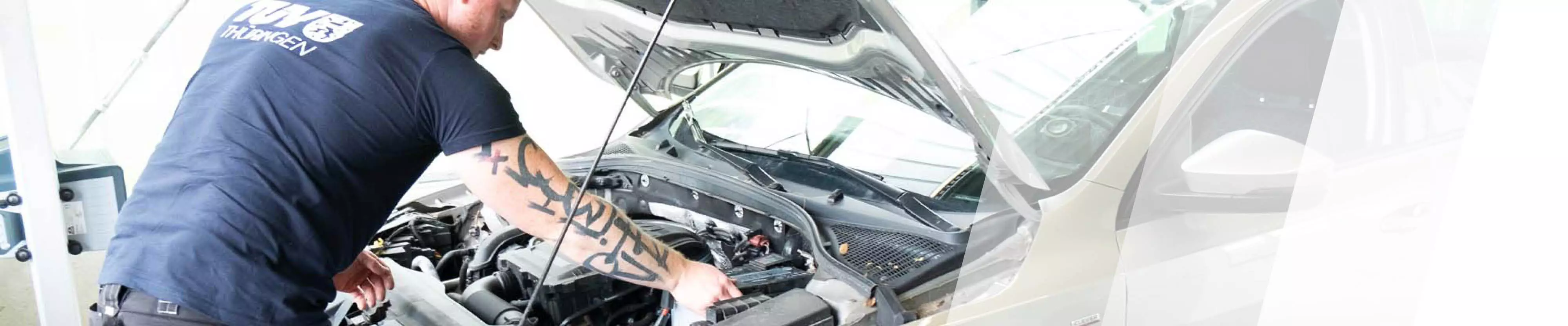 Prüfer schaut unter die Motorhaube eines Autos