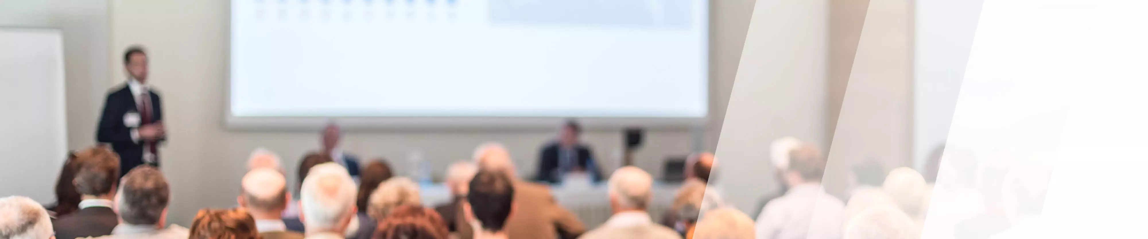 Referent präsentiert auf einer Leinwand einen Vortrag